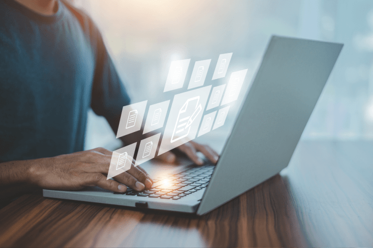 A man types on a laptop, with various icons displayed on the screen, representing managed IT services in Charleston.